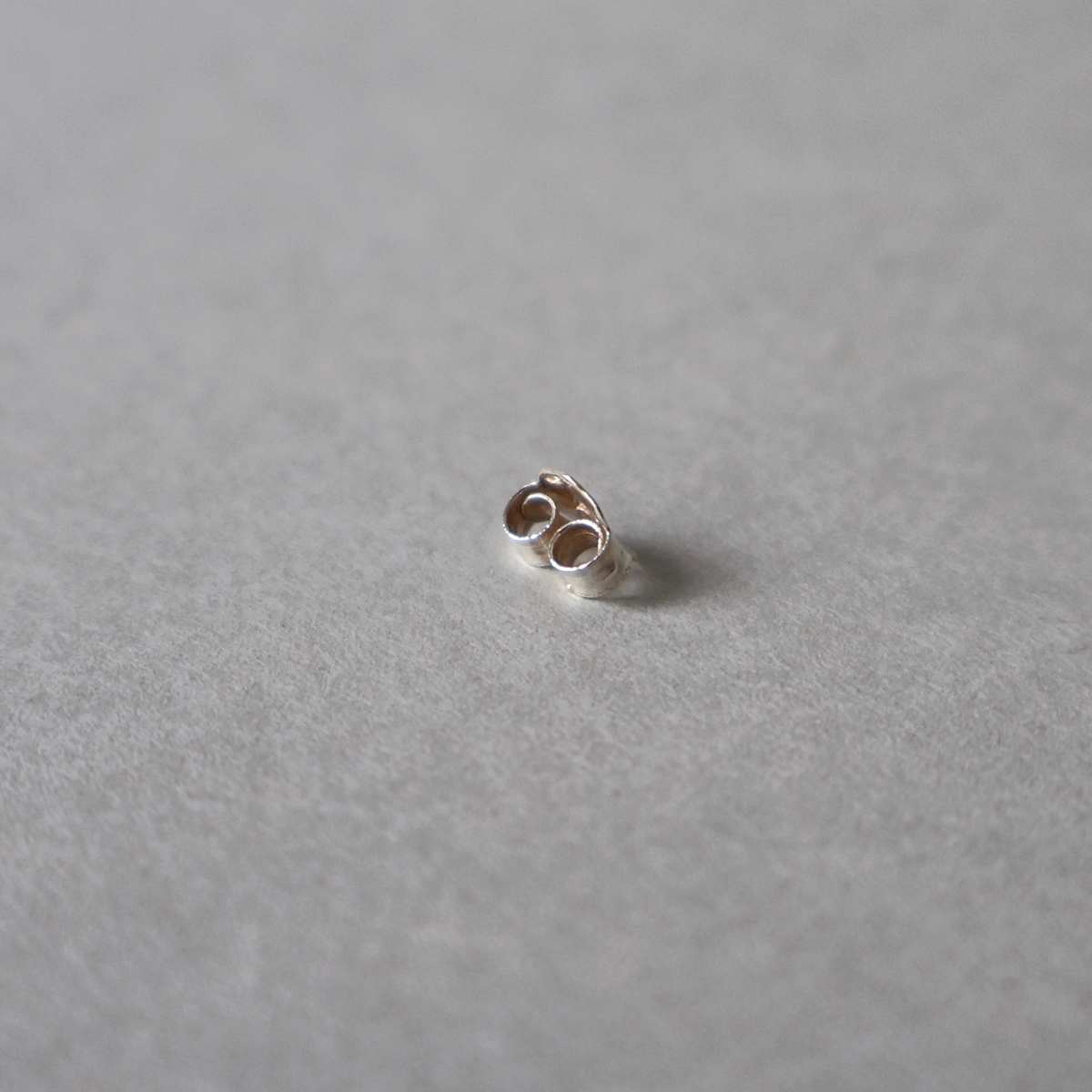 A close up picture of a butterfly back for earrings and studs.
